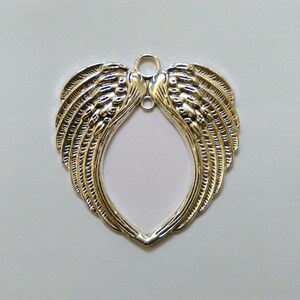 May include: Silver metal angel wings charm with a loop at the top for hanging. The wings are detailed with a feathery design.