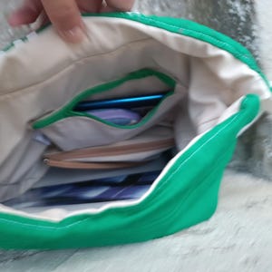 Esta mochila verde tiene un bolsillo interior con cremallera para guardar tus objetos más preciados