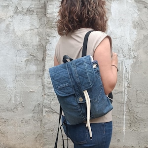 Rugzak van denim met klep en trekkoorden. Rugzak van gerecycled denim. Rugzak van gerecyclede jeans.