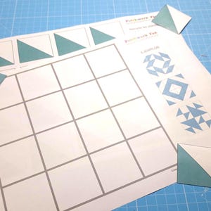 Puede incluir: Una hoja de papel blanca con una cuadrícula de 18 cuadrados. El papel tiene las palabras "Patchwork Fun" y "Patchwork Fun" impresas en él. Hay varios triángulos y cuadrados de papel azul en el papel.
