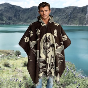 May include: A hooded brown poncho with a wolf design and paw prints. The poncho features a full-length zipper and a cream-colored wolf illustration on the front. The poncho is made of a soft, woven material.