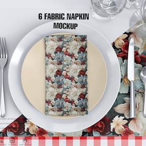 May include: A mockup of six fabric napkins folded and placed on a white plate with a beige inner plate. The plate is on a floral tablecloth with a red and white checkered border. The napkins have a floral pattern with red, white, and blue flowers.