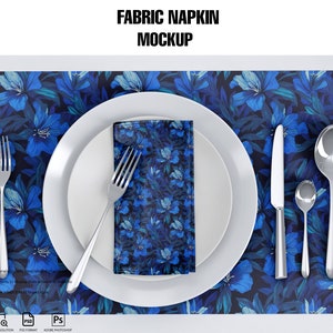 May include: A white plate with a blue floral fabric napkin, a fork, a knife, and two spoons on a blue floral placemat.  The text "FABRIC NAPKIN MOCKUP" is at the top of the image.