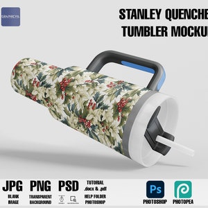 May include: A white Stanley Quencher tumbler mockup with a black handle and a blue accent. The tumbler is wrapped with a green and white holly pattern with red berries. The text "STANLEY QUENCHER TUMBLER MOCKUP" is at the top of the image. The text "JPG PNG PSD" is at the bottom of the image, along with the text "BLANK IMAGE", "TRANSPARENT BACKGROUND", and "TUTORIAL .docx & .pdf HELP FOLDER PHOTOSHOP". The text "Ps PHOTOSHOP PHOTOPEA" is also at the bottom of the image.