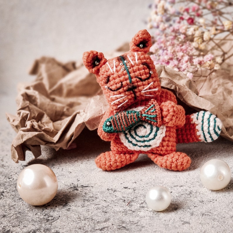 Close-up of a cute crochet kitty amigurumi, handmade with intricate details. Follow this digital pattern to create your own adorable kitty.