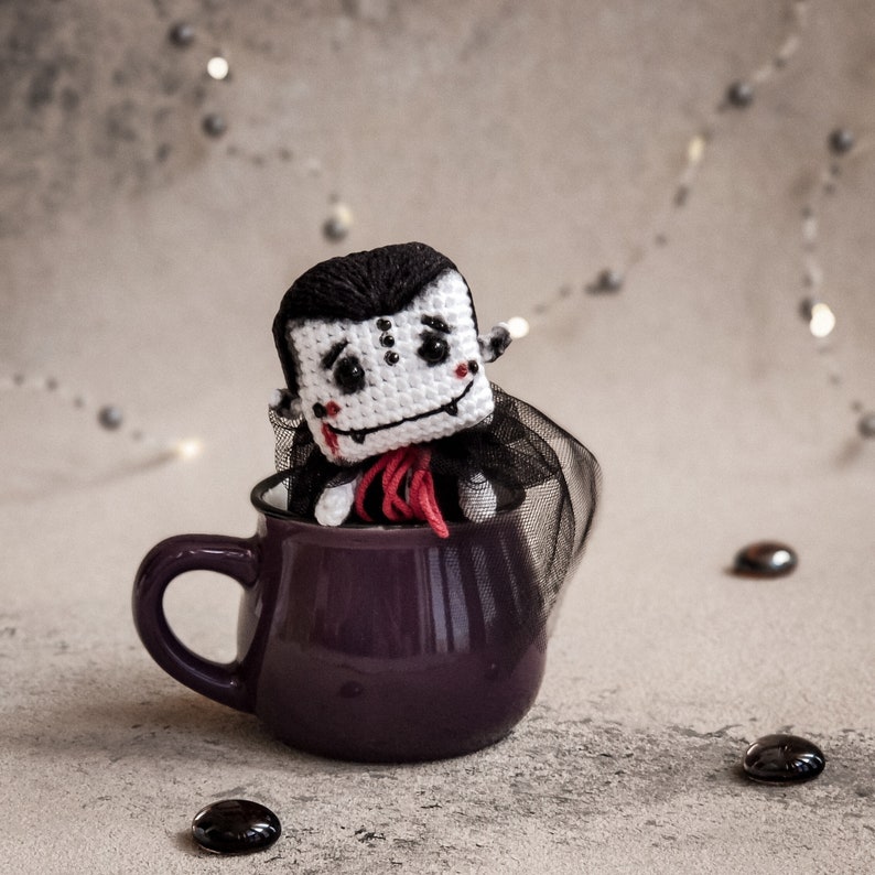 A close-up of two crochet vampires, ideal as Halloween decorations or heartfelt handmade gifts. DIY tutorial for creating unique amigurumi toys with love and care.