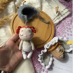 The butterfly doll resting on natural linen fabric, emphasizing the eco-friendly, handmade appeal. Ideal for those who value sustainable, creative gifts crafted with love.
 Image of the Doll with Pattern Materials: The butterfly doll displayed alongside yarn and crochet tools, highlighting the DIY aspect of the pattern. Perfect for those seeking unique handmade crafts, ideal as gifts or personal projects.