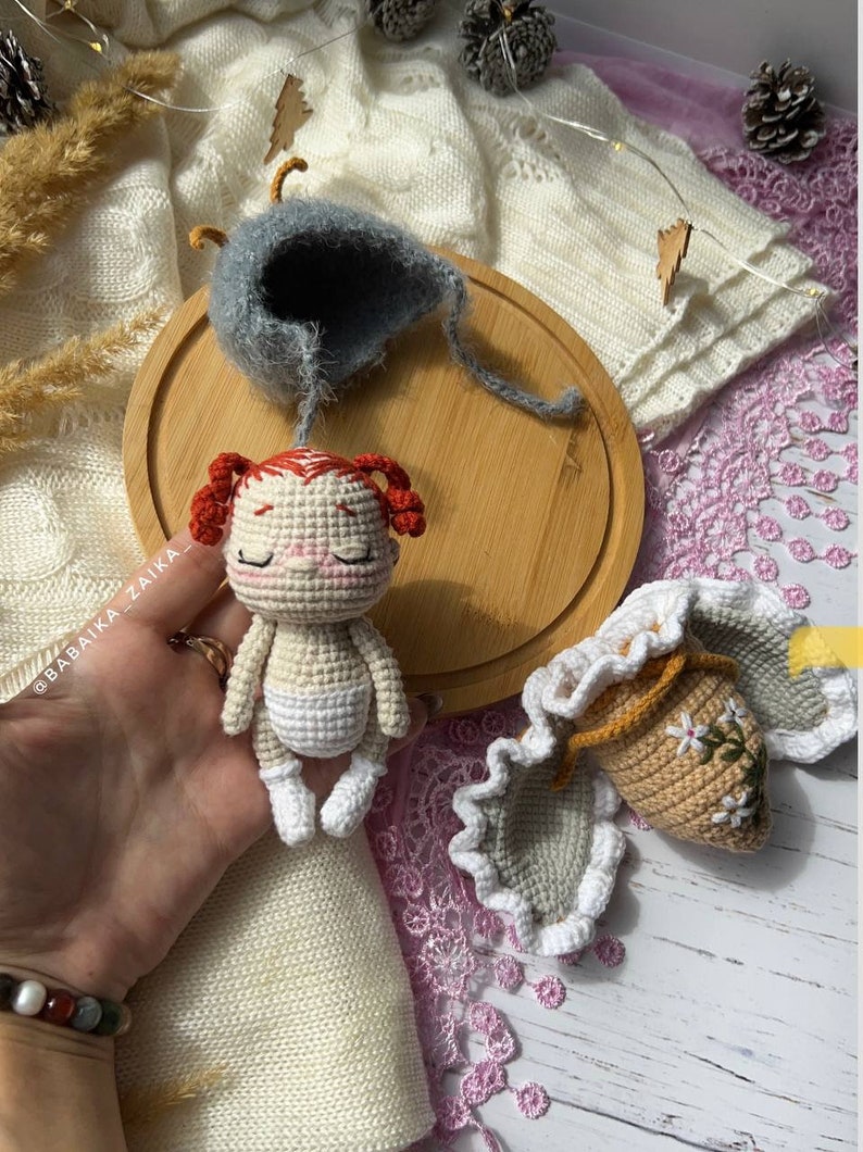 The butterfly doll resting on natural linen fabric, emphasizing the eco-friendly, handmade appeal. Ideal for those who value sustainable, creative gifts crafted with love.
 Image of the Doll with Pattern Materials: The butterfly doll displayed alongside yarn and crochet tools, highlighting the DIY aspect of the pattern. Perfect for those seeking unique handmade crafts, ideal as gifts or personal projects.