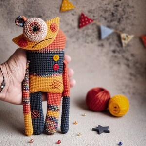 Close-up of a crochet sad monster toy, Mr. Lu-Lu, featuring detailed stitching and a colorful design perfect for handmade collections.