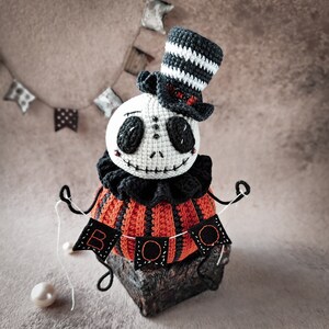 A cozy and eerie Halloween setup with the Jack pumpkin amigurumi figure as the centerpiece. The "BOO" sign, top hat, and spooky details make it a perfect handmade Halloween decoration.