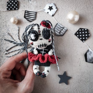 Skeleton doll being held by hand to showcase its detailed crochet work and design.