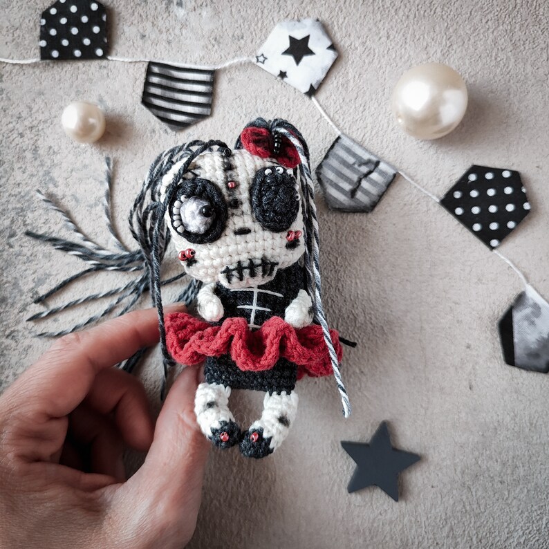 Skeleton doll being held by hand to showcase its detailed crochet work and design.