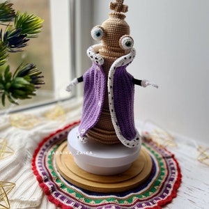 Kinger amigurumi doll crafted with fine details, holding a miniature accessory, perfect as a Halloween crochet gift.