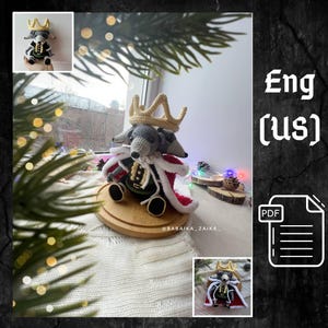 May include: A crocheted grey rat figurine wearing a gold crown and a red and white cape. The rat is seated on a wooden base. The image includes a smaller inset image of the same figurine and the text "@BABAIKA_ZAIKA_".