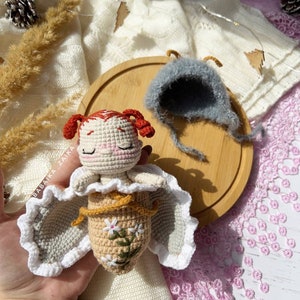 Detailed view of the amigurumi butterfly baby doll's face, showcasing its delicate handmade features. This eco-friendly crochet pattern allows for creating a soft, safe toy for children, filled with love and crafted with care.