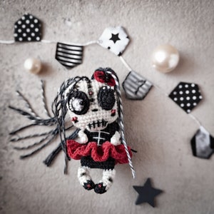 Doll displayed on a flat surface with Halloween props like stars and stripes, creating a spooky vibe.