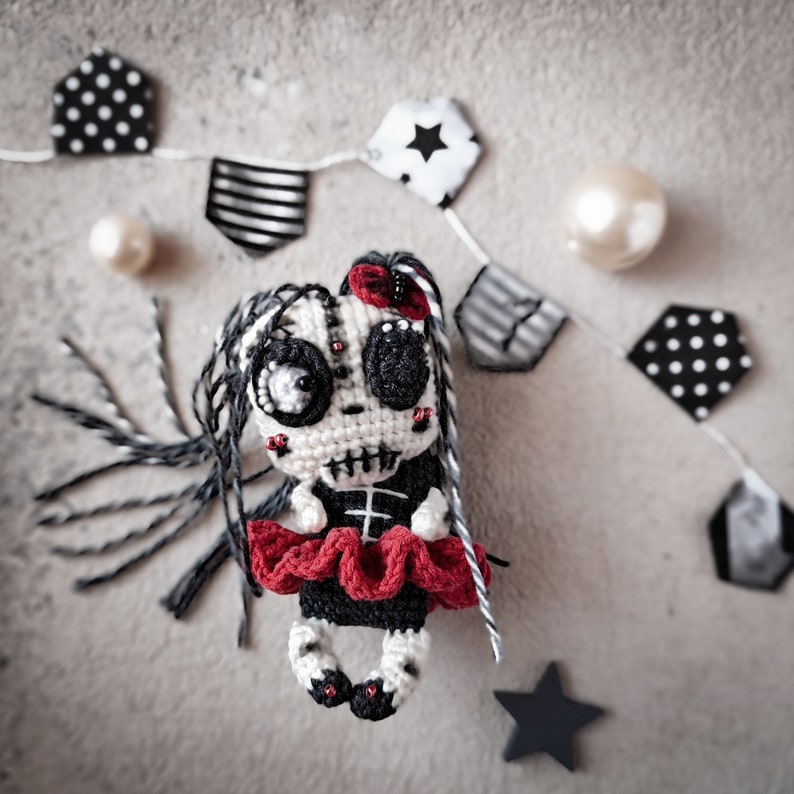 Doll displayed on a flat surface with Halloween props like stars and stripes, creating a spooky vibe.