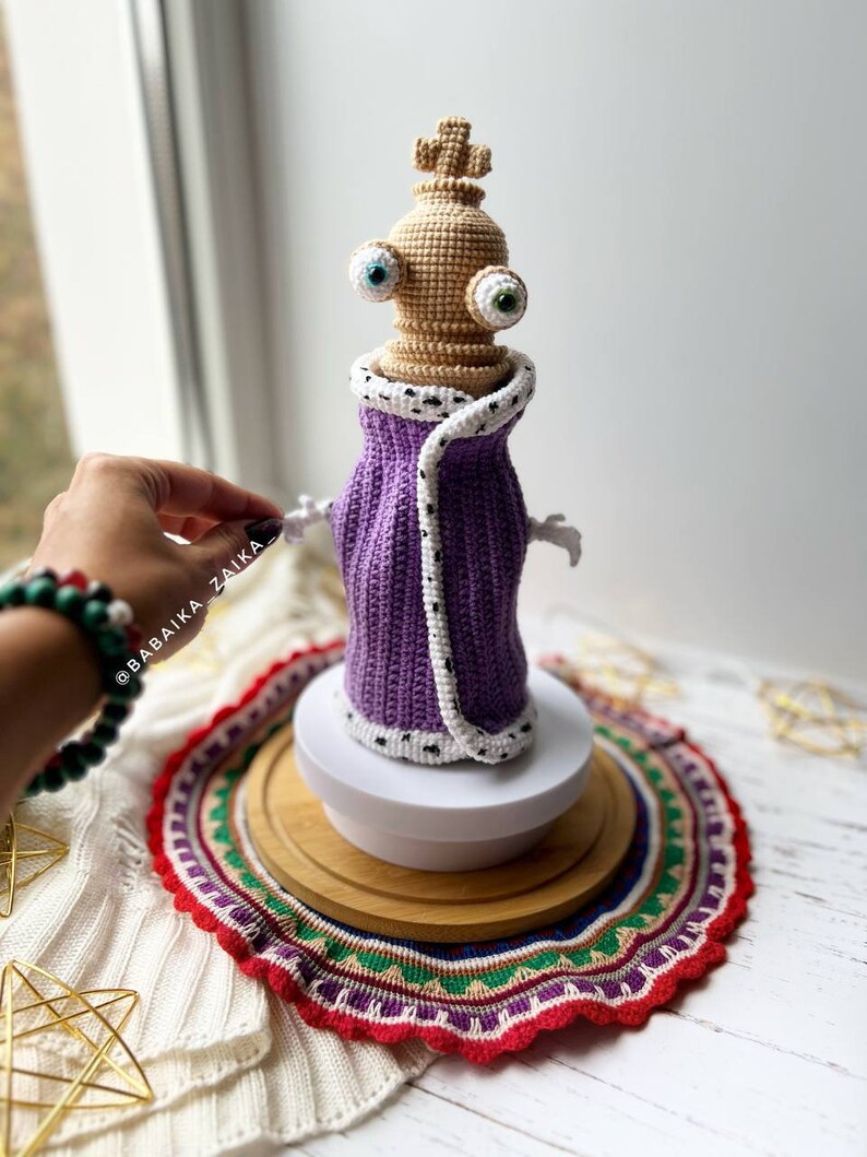 Amigurumi Kinger crochet pattern in a chess-themed setting, designed for crafters who enjoy making unique character dolls