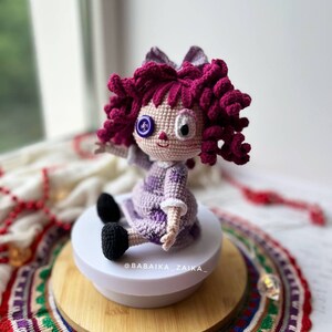 Side view of the doll sitting on a wooden base, with emphasis on the hair texture and the doll's profile.