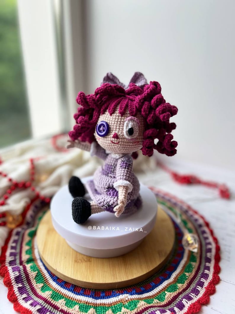 Side view of the doll sitting on a wooden base, with emphasis on the hair texture and the doll's profile.