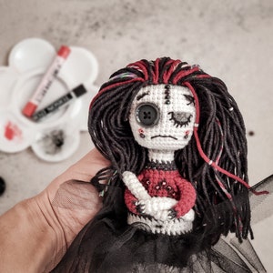 Gothic amigurumi doll with long tulle skirt, a dramatic expression, and a stitched heart. A perfect handmade Halloween decoration.