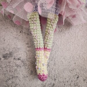 Close-up of the doll's face, highlighting intricate amigurumi details and button accents.