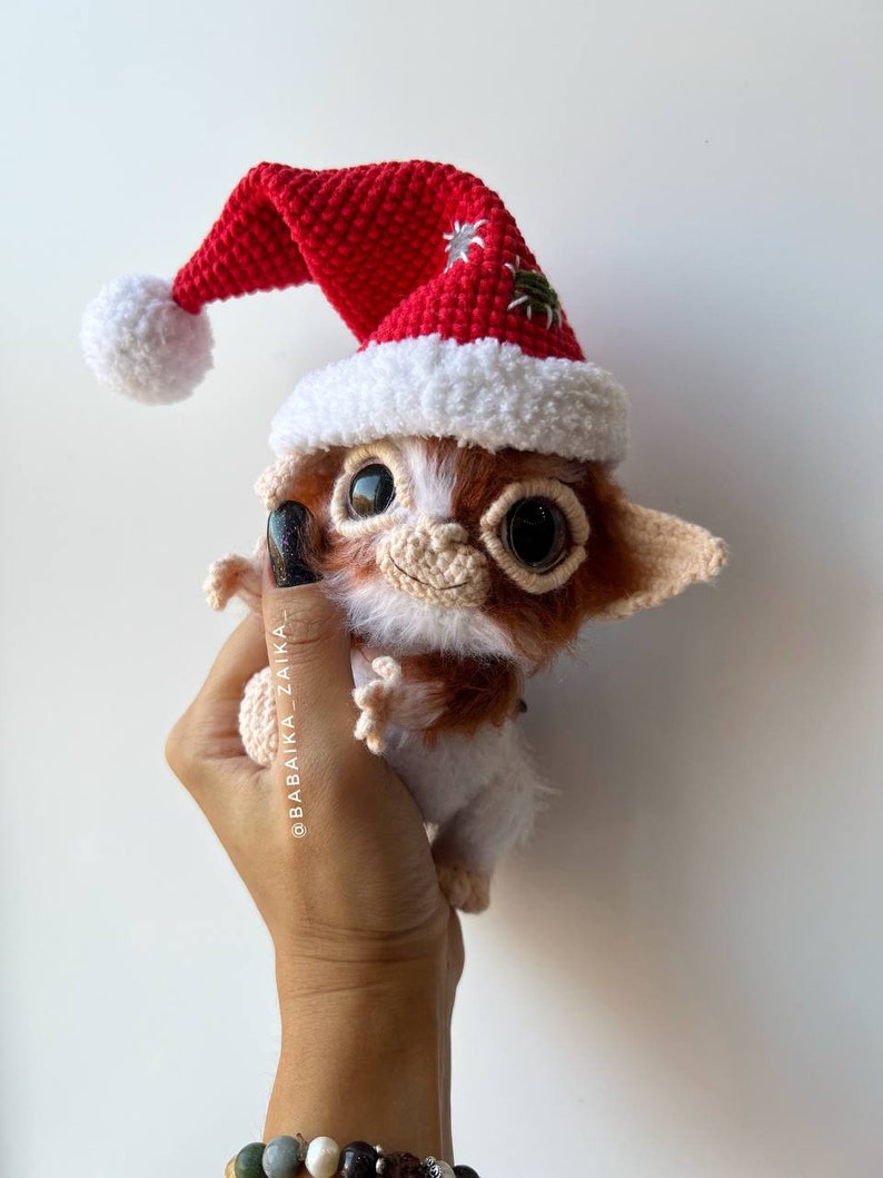 Gizmo toy with a Christmas-themed bag, handmade crochet design, ideal for festive home decor and as a collectible.