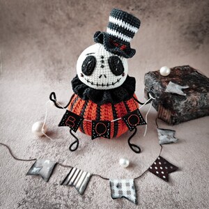 Close-up of the Jack pumpkin doll’s face, focusing on the creepy yet charming expression with stitched details. The striped hat and black frilly collar complete the Halloween look.