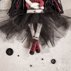 Voodoo doll crochet pattern, detailed with black and red hair, stitched eyes, and eerie features. Great for spooky handmade gifts.