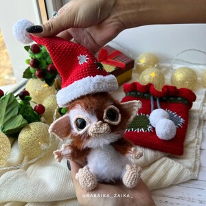 Christmas-themed Gizmo toy in red bag, eco-friendly crochet pattern for festive home decoration or gifting.