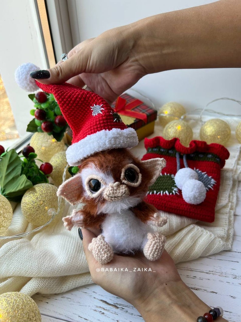 Christmas-themed Gizmo toy in red bag, eco-friendly crochet pattern for festive home decoration or gifting.