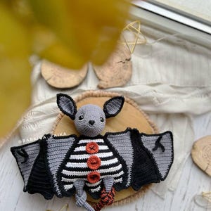 Amigurumi Halloween bat with striped belly and wings, spooky crochet plush pattern for DIY decor and gifts.