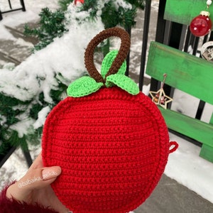 Two crochet foxes set against natural greenery, highlighting their handmade charm. A digital pattern for eco-conscious gifts.