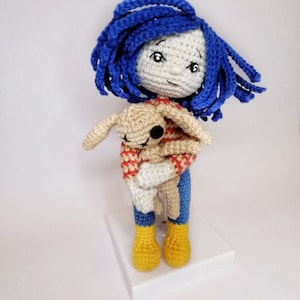 A detailed view of the Coraline doll and voodoo bunny together, showcasing the intricate crochet texture and handmade details.e crochet texture and handmade details.