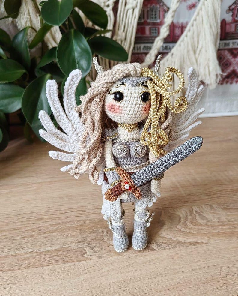 Back view showing detachable crocheted angel wings on viking doll