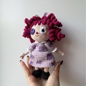 The doll held in hand, focusing on the details of the hair and the expression on the doll's face.