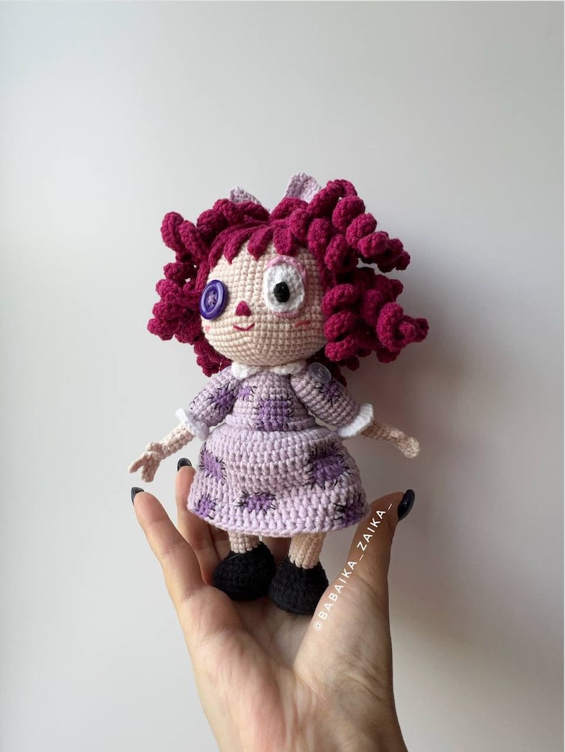 The doll held in hand, focusing on the details of the hair and the expression on the doll's face.