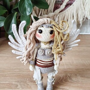 Close-up of amigurumi valkyrie face with blond braids and helmet