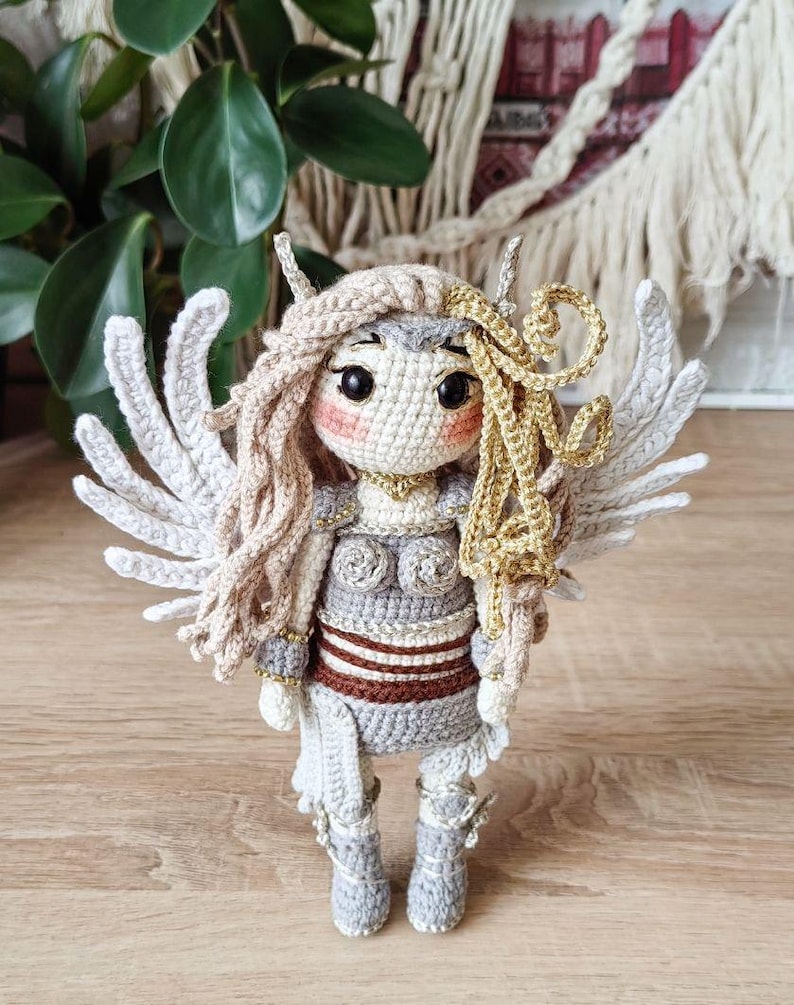 Close-up of amigurumi valkyrie face with blond braids and helmet