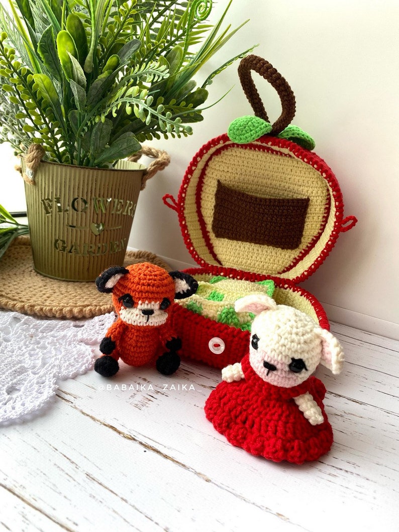 Detailed close-up of an amigurumi baby fox and an apple bag, showcasing the intricate crochet design. Perfect for DIY enthusiasts.