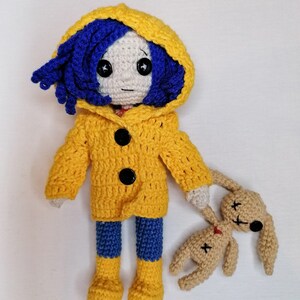 A final artistic shot of the crochet Coraline doll and voodoo bunny together, demonstrating the high-quality craftsmanship of the amigurumi set.