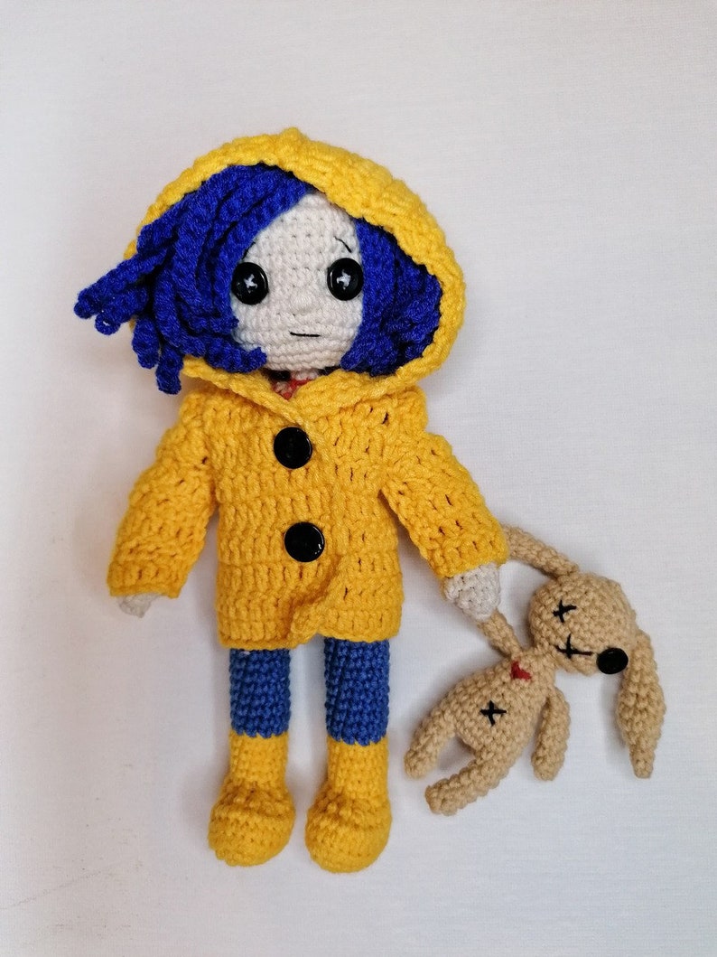 A final artistic shot of the crochet Coraline doll and voodoo bunny together, demonstrating the high-quality craftsmanship of the amigurumi set.