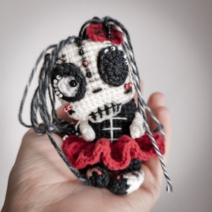Side view of the amigurumi skeleton doll held in hand, highlighting its size and intricate design.