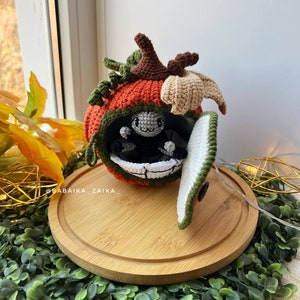 Detailed side view of a handmade amigurumi pumpkin house with a cute crochet spider. Unique design for Halloween decor. Digital pattern for DIY lovers.