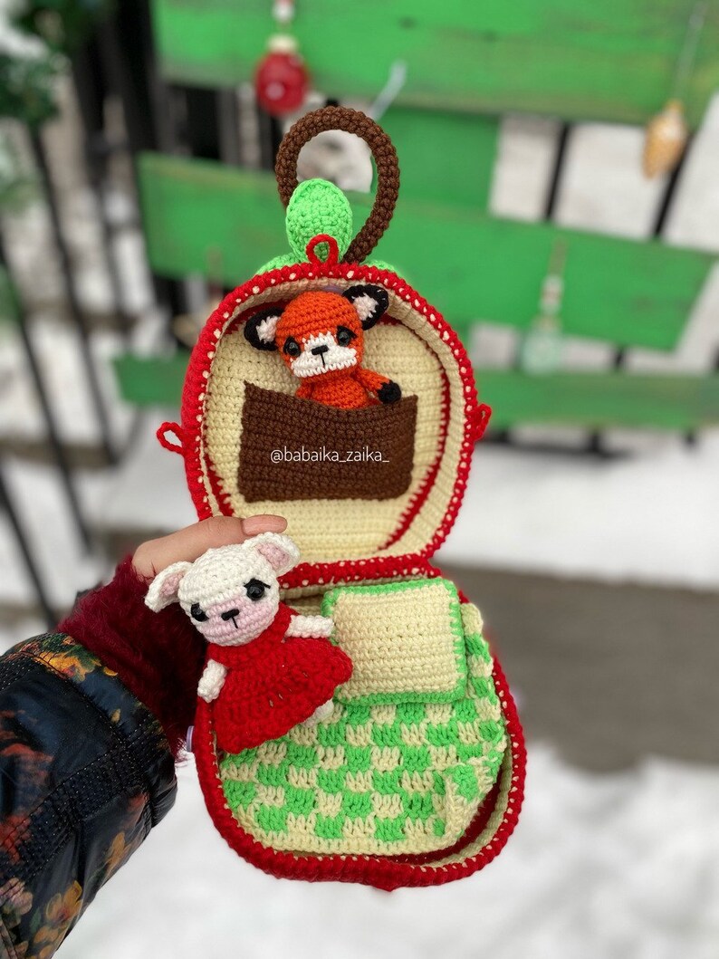 Two adorable crochet foxes nestled inside an apple-shaped bag. Digital PDF pattern for crafting personalized, handmade toys.