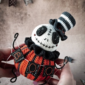 A dramatic angle of the Jack pumpkin figure, capturing the essence of a spooky yet playful Halloween character. The vibrant orange crochet dress contrasts beautifully with the darker elements.