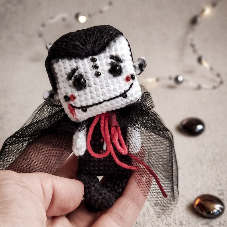 Crochet vampire toy on a red gift box – an original and unique handmade present. Follow this digital PDF tutorial to create a special toy that will make a perfect eco-friendly Halloween gift.