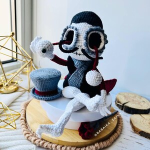 Detailed view of Mr. Santa Muerte amigurumi holding a red crochet rose, ideal for Halloween ornament collection.