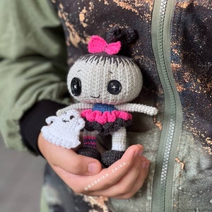 A close-up of the doll standing against a rough-textured wall, giving off a rustic and eerie Halloween vibe. The ghost toy adds an extra spooky charm to the set, making it great for home decor.