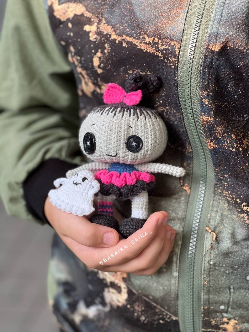 A close-up of the doll standing against a rough-textured wall, giving off a rustic and eerie Halloween vibe. The ghost toy adds an extra spooky charm to the set, making it great for home decor.
